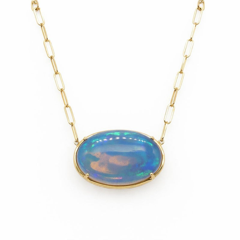 A captivating oval opal glows with brilliant flashes of blue and green, suspended in polished 14K yellow gold from a modern paperclip chain. The open prong setting allows the opal's vibrant color play to shine, creating an effortlessly elegant necklace with a fresh, contemporary style.