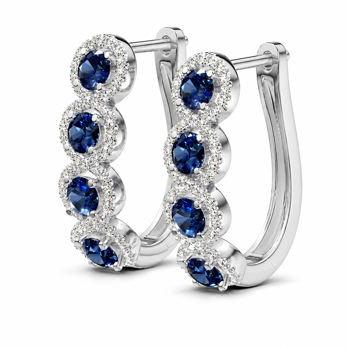 Rich blue sapphires line these 14K white gold earrings, each framed by a diamond halo for a beautiful contrast of deep color and brilliance. The graduating design creates a dramatic sweep of sapphire blue and diamond sparkle.