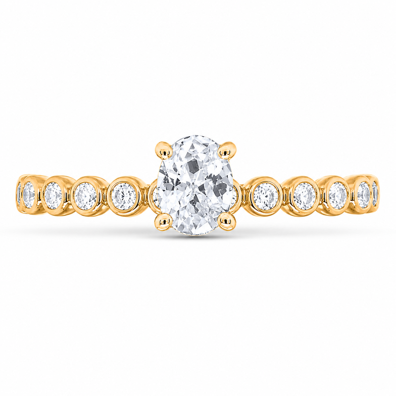 Showcasing a modern blend of texture and sparkle, this engagement ring features a glowing 1/3 CT oval center diamond set in 10K yellow gold. Highlighted by a unique bezel-beaded double band adorned with round accent diamonds totaling 1/2 CTW, it offers a chic, sophisticated profile. All of our diamonds are 100% natural, earth-mined, and ethically sourced.