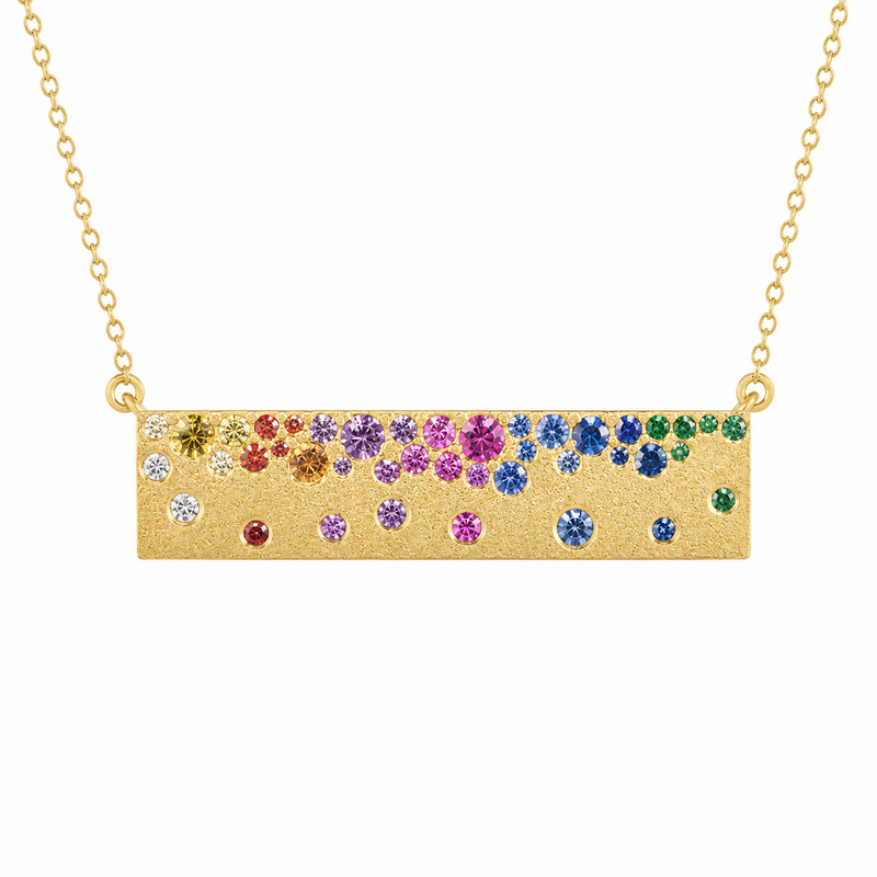 A vibrant blend of rainbow sapphires and vivid tsavorites creates a colorful cascade across this satin-finished 14K yellow gold bar pendant. The graduated arrangement of gemstones adds depth, movement, and playful brilliance, while the adjustable 16-18 inch chain offers versatile styling.