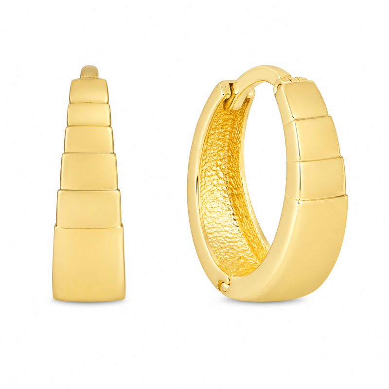A pair of gold huggie hoop earrings shown on a plain white background, with one earring facing forward to show the stacked rectangular exterior and the other angled to show the textured gold interior.