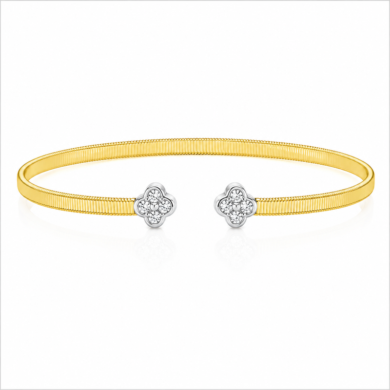 Two diamond clovers accent the open ends of this 14K yellow and white gold bangle. The round diamonds total 1/5 carat total weight, adding a bright finish to the ribbed yellow gold design.